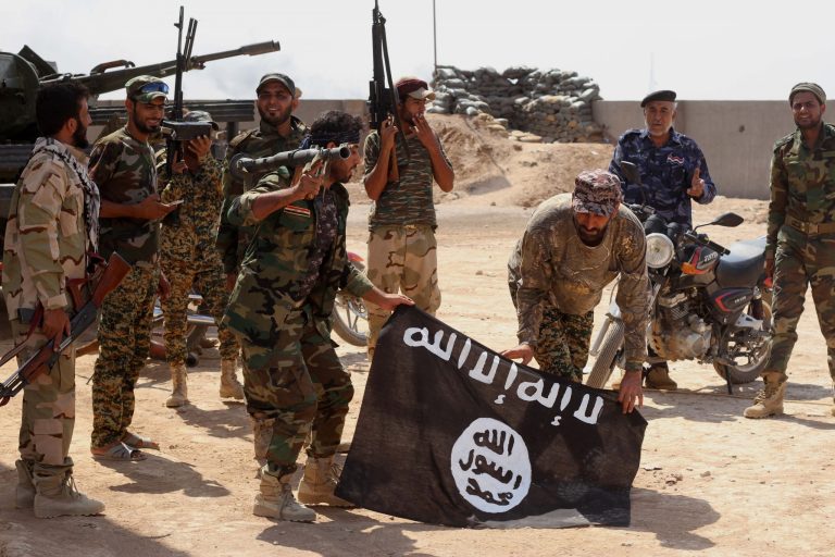 Iraqi security forces hold a flag of the Islamic State group they captured during an operation outside Amirli, some 105 miles north of Baghdad, Iraq, Monday. (AP Photo)