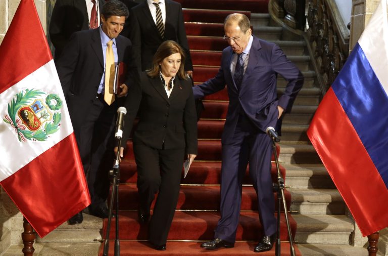 Russian's Foreign Minister Sergey Lavrov, right, helps Peru's Foreign Miniterv Eda Rivas before a joint press conference at the Foreign Ministry building in Lima, Peru, Wednesday, April 30, 2014. Lavrov is Lima, for a one day visit in his tour of Latin America. (AP Photo/Martin Mejia)