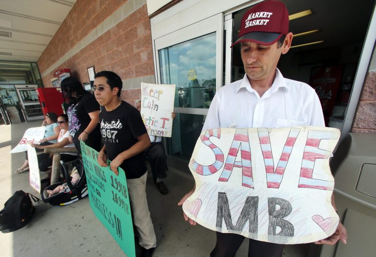 Ardian Zoto, right, an employee of Market Basket for six years, holds a sign outside the supermarket in Danvers, Mass., Monday, Aug. 4, 2014. Executives at the troubled Market Basket supermarket chain in New England say they have heard from employees who are 