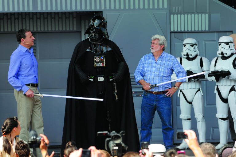 FILE - In this May 20, 2011 file photo, Disney CEO Robert Iger, left, and Star Wars creator George Lucas, third from right, talk to the Star Wars movie character Darth Vader, center, onstage at the Disney Hollywood Studios theme park during the re-opening celebration of the Star Tours motion simulation ride in Lake Buena Vista, Fla. Disney announced on Oct. 30, 2012 that it would buy Lucasfilm for $4.05 billion and resume making 