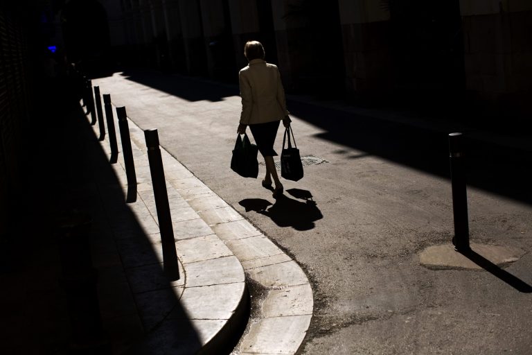   FILE - In this Thursday May 23 2013, file photo, a woman carrying bags with food walks along the street as she leaves a vegetables market in a Barcelona, Catalonia, Spain. In an Associated Press poll released Tuesday, Sept. 17, 2013, more than two dozen economists suggests that global growth will remain below full health this year and next. (AP Photo/Emilio Morenatti, File)  