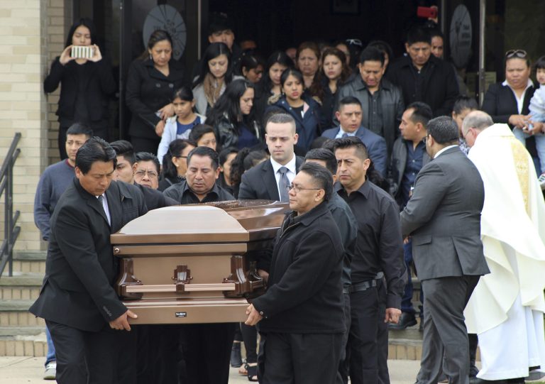 In this April 19, 2017 file photo, the casket of Justin Llivicura is carried from St. Joseph the Worker Church after Llivicura's funeral in East Patchogue, N.Y. Llivicura, 16, was one of four young men found slain in a suspected MS-13 gang killing in a park in Central Islip, N.Y., on April 12. The gang has been blamed for the deaths of nearly a dozen young people in blue-collar Brentwood and Central Islip since the school year began. (AP Photo/Frank Eltman, File)