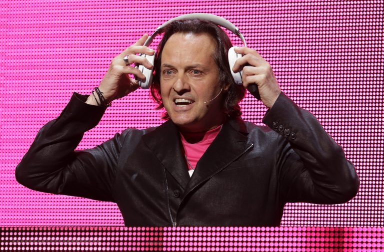 T-Mobile CEO John Legere puts on headphones as he announces a new music streaming service at T-Mobile's Uncarrier 5.0 event, Wednesday, June 18, 2014, in Seattle. (AP Photo/Ted S. Warren)