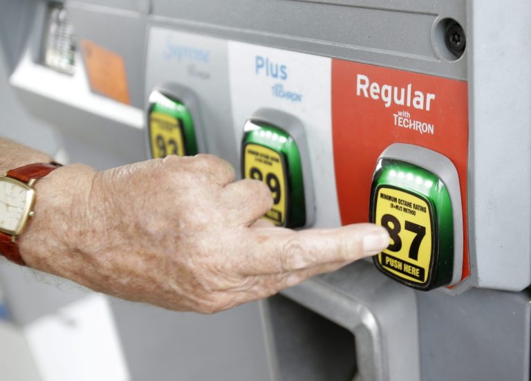 FILE - In this Wednesday, June 4, 2014 file photo, Marty Mascio of Pembroke Pines, Fla., selects a grade of gasoline as he fills up his car at a Chevron station in Pembroke Pines. Lifting restrictions on exports of crude oil from the U.S. would benefit the U.S. economy and lead to a slight dip in gasoline prices, according to a study released Tuesday, Sept. 9, 2014. (AP Photo/Wilfredo Lee, File)