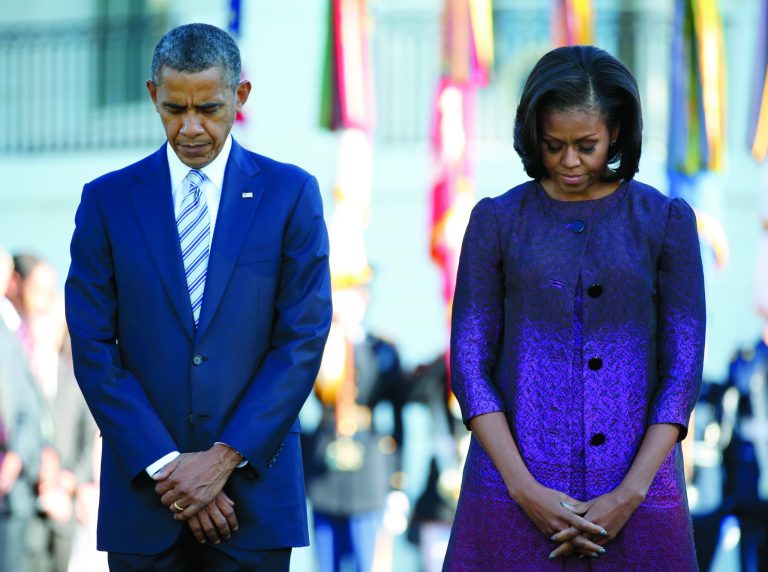 President Barack Obama and first lady Michelle Obama, joined by members of the White House staff pause during a moment of silence to mark the 11th anniversary of the Sept, 11th, Tuesday, Sept. 11, 2012, on the South Lawn of the White House in Washington. (AP Photo/Carolyn Kaster)
