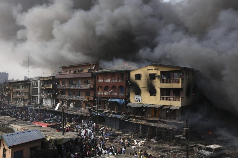   Residents look as a fire burns out a residential homes and a warehouse on Lagos Island in Lagos, Nigeria, Wednesday, Dec. 26, 2012. An explosion ripped through a warehouse Wednesday where witnesses say fireworks were stored in Nigeria's largest city, sparking a fire. It wasn't immediately clear if anyone was injured in the blast that firefighters and locals struggled to contain. (Ap Photos/Sunday Alamba)  