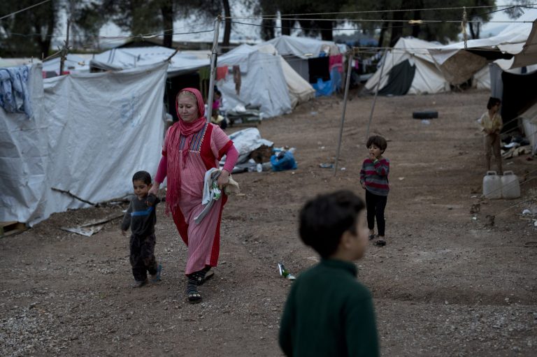 In this Thursday, Sept. 22, 2016 photo, Syrian refugees walk among tents at the Ritsona camp for refugees and other migrants north of Athens. (AP Photo/Petros Giannakouris)