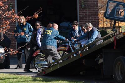 FBI and IRS agents help to push a motorcycle onto a tow truck outside the house of Councimen Harry Thomas Jr., Washington D.C., Fri, Dec 2, 2011