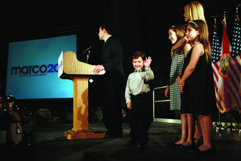Florida Sen. Marco Rubio worries about being away from his kids. Here, at his election victory, he's with wife Jeanette  and daughters Amanda (C) and Daniella (R) and waiving son Anthony. (Photo by Joe Raedle/Getty Images)