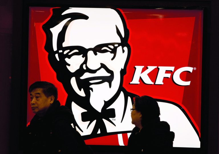 A Chinese couple walk past a KFC restaurant at a shopping mall in Beijing Monday, Feb. 25, 2013. KFC launched a campaign Monday to rebuild its battered brand in China, promising tighter quality control after a scandal over misuse of drugs by its poultry suppliers. (AP Photo/Andy Wong)