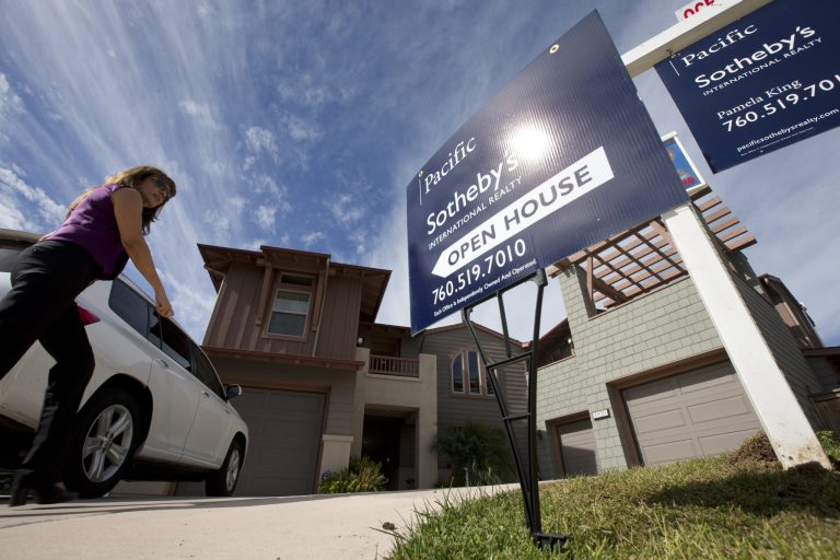   In this Wednesday, Nov. 14, 2012, photo, a woman walks towards a home for sale during a viewing for brokers in Leucadia, Calif. Americans bought new homes in November 2012 at the fastest pace in more than two and a half years, further evidence of a sustained housing recovery.(AP Photo/Gregory Bull, File)  