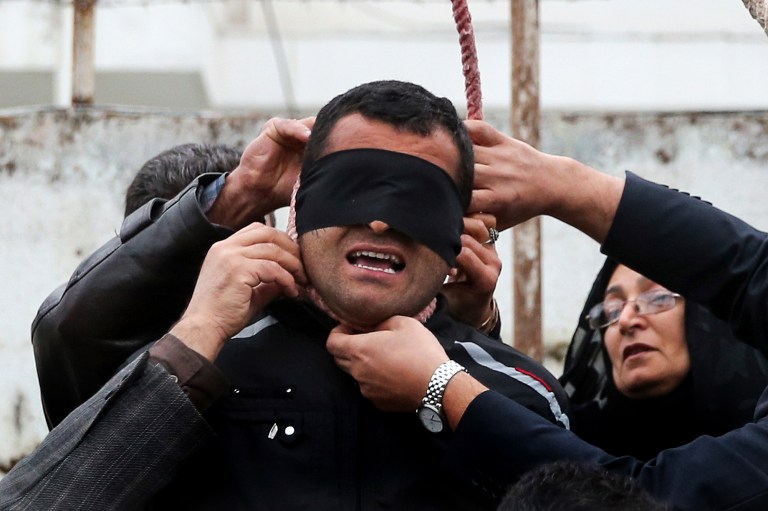 This picture provided by ISNA, a semi-official news agency, taken on Tuesday, April 15, 2014 shows Maryam Hosseinzadeh, right, and her husband Abdolghani, left, removing the noose from the neck of blindfolded Bilal who was convicted of murdering their son Abdollah in the northern city of Nour, Iran. Bilal who was convicted of killing Abdollah Hosseinzadeh, was pardoned by the victim's family moments before being executed. (AP Photo/ISNA, Arash Khamoushi)