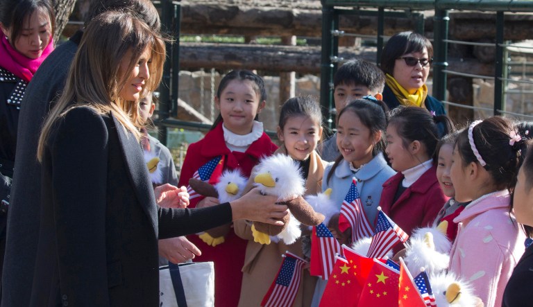 First lady Melania Trump handed out bald eagle dolls to Chinese children holding U.S. and Chinese flags near the Panda enclosure at the zoo in Beijing on Friday. (AP Photo/Ng Han Guan)