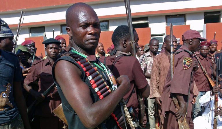 In this photo taken on, Sunday, May 18, 2014, armed hunters gather before looking for around 300 abducted school girls in Maiduguri, Nigeria. Hundreds of hunters armed with homemade rifles, poisoned arrows and amulets say their spiritual powers can lead them to the nearly 300 schoolgirls abducted by Islamic extremists. (AP Photo/Haruna Umar)