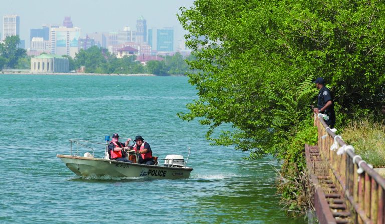 Detroit police look over the scene in the Detroit River in Detroit, Tuesday, July 17, 2012 where the U.S. Coast Guard says the bodies of a man and a woman whose heads, hands and feet were cut off were found floating. Detroit Police say 911 calls reported the gruesome discovery of the floating torsos about 6:45 a.m. Tuesday. (AP Photo/Carlos Osorio)