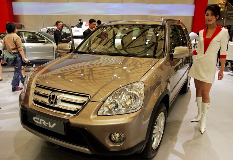 FILE - In this April 21, 2005 file photo, a model poses by a Honda's CR-V at Auto Shanghai 2005 exhibition in Shanghai, China. Honda, Mazda and Nissan are recalling millions of vehicles globally for defective airbags manufactured by supplier Takata Corp. that could possibly explode. No accidents have been reported related to recalls Monday, June 23, 2014. Honda Motor Co. recalled 2.03 million vehicles for the airbag problem, including 1.02 million in North America and nearly 669,000 in Japan. The models recalled at Honda include the Fit, Element and CR-V, manufactured between 2000 and 2005. (AP Photo/Eugene Hoshiko, File)