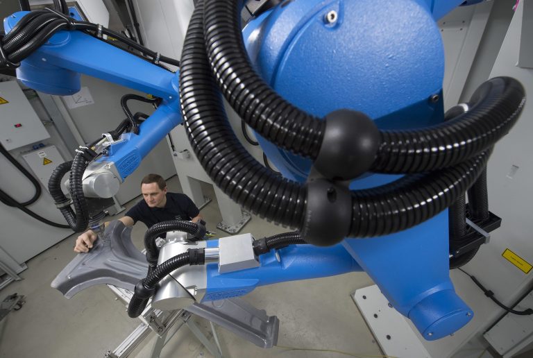 Technology developer Jan Langebach sets up a Jenoptik-Votan BIM laser machine for laser cutting of 3D plastic automative parts during a presentation on March 7. (AP Photo/Jens Meyer).