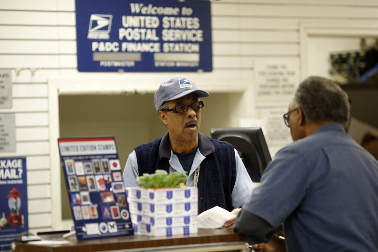 An employee helps a customer at the post office on Evans Street in San Francisco, California. (Getty images)