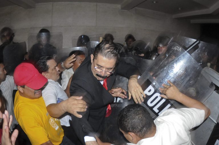 Manuel Zelaya, center, former Honduran President and now congressman, is forcibly expelled by riot police from the congress building along with other members of the Libertad y Refundacion, LIBRE party, in Tegucigalpa, Honduras, Tuesday, May 13 2014. Hundreds of Zelaya's supporters clashed with riot police and soldiers and where eventually expelled violently from the building. (AP Photo/Fernando Antonio)