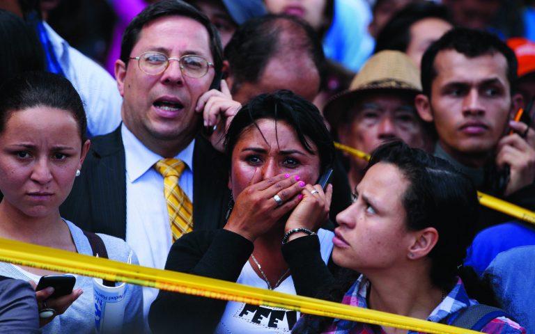 FILE - In this May 15, 2012 file photo, pedestrians look at the scene after a bomb exploded in Bogota, Colombia. A 