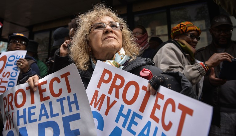A demonstrator holds up a sign that reads "Protect My Healthcare" during a protest outside the Republican Party's annual policy retreat in Philadelphia, U.S., on Thursday, Jan. 26, 2017. President Trump rallied Republican lawmakers on Thursday to act quickly on priorities including a new health care law after years of partisan gridlock between the White House and Congress.