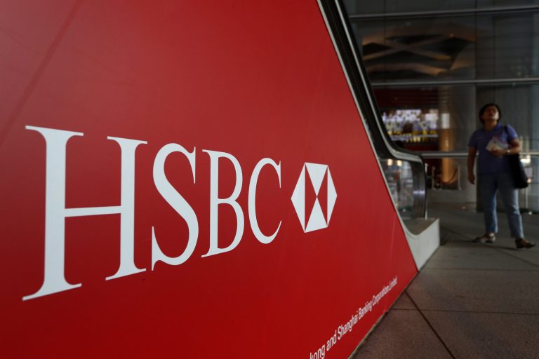   FILE -- In a July 30, 2012 file photo people walk past a logo of HSBC headquarters in Hong Kong . HSBC, the British banking giant, will pay $1.9 billion to settle a money-laundering probe by federal and state authorities in the United States, a law enforcement official said Monday Dec. 10, 2012. (AP Photo/Vincent Yu, file)  