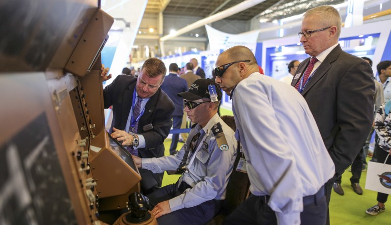 An attendee sits on a Boeing Co. KC-46 Pegasus refueling aircraft simulator at company's booth during the Aero India air show at Air Force Station Yelahanka in Bengaluru, India, on Wednesday, Feb. 15, 2017.