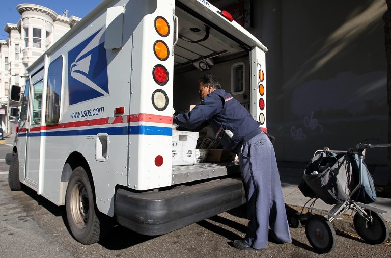 US Postal Service letter carrier Juan Padilla arranges mail in his truck while on his delivery route on Dec. 5, 2011 in San Francisco, Calif. (Photo by Justin Sullivan/Getty images)