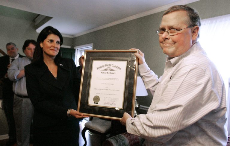   FILE -In this Friday, Oct. 26, 2012 file photo, Associated Press reporter Jim Davenport receives The Order of the Palmetto, South Carolina's highest civilian honor, from S.C. Gov. Nikki Haley at his home in Columbia, S.C. South Carolina Associated Press reporter Jim Davenport has died. He was 54. He was a tenacious reporter who made it his mission to inform people in South Carolina about what their governors, lawmakers and other powerful officials were doing with their tax money and their influence. (AP Photo/ Mary Ann Chastain, File)  