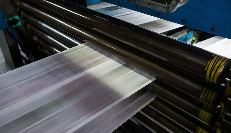 Newsprint passes through a rotary press