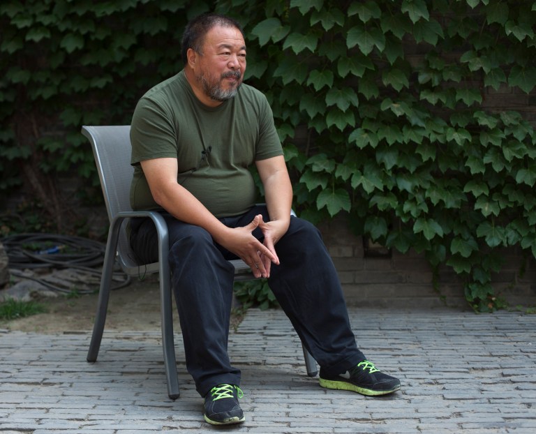 FILE - In this May 22, 2013 file photo, artist Ai Weiwei speaks to journalists at the courtyard of his studio in Beijing. Ai, who helped make his name smashing a valuable vase in the name of art, said Wednesday, Feb. 19, 2014 that he was miffed about another artist destroying one of his vases in Florida. Maximo Caminero was charged with criminal mischief after destroying a vase valued at $1 million that was part of Ai's exhibit at the Perez Art Museum Miami. The Florida artist said he smashed the vase Sunday, Feb. 16 to protest the institution's lack of displays of local artists. Ai said Wednesday that he did not agree with Caminero's tactic. (AP Photo/Alexander F. Yuan, File)