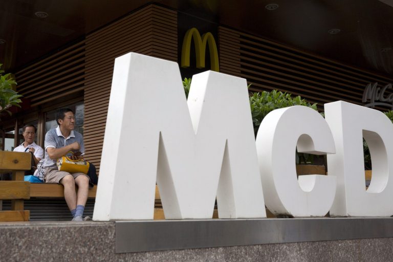 FILE - In this July 22, 2014 file photo, a man rests outside a McDonald's restaurant in Beijing. McDonald's reports quarterly financial results on Tuesday, Oct. 21, 2014. (AP Photo/Ng Han Guan, File)