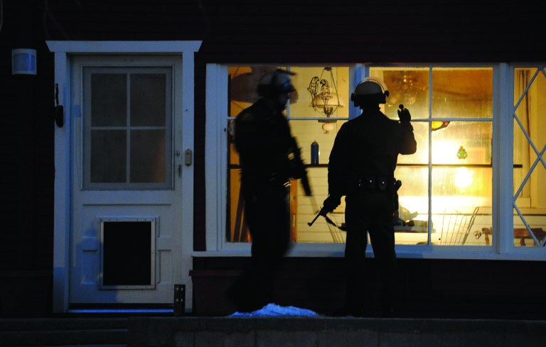 Police officers check a house along Switzerland Avenue for murder suspect, former Los Angeles Police Department Officer Christopher Dorner, Thursday, Feb. 7, 2013, in Big Bear Lake, Calif. (AP Photo/Los Angeles Times, Wally Skalij)
