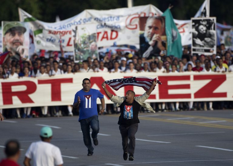 A security officer chases a man waving an American flag moments before the start of the May Day march in Havana, Cuba, Monday, May 1, 2017. Plainclothes officers struggled to control the man but eventually lifted him off the ground and hauled him away in front of foreign and Cuban journalists. (AP Photo/Desmond Boylan)