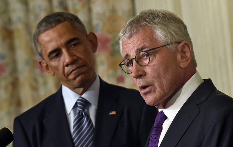 President Barack Obama, left, listens as Defense Secretary Chuck Hagel, right, talks about his resignation during an event in the State Dining Room of the White House in Washington, Monday, Nov. 24, 2014. Hagel is stepping down under pressure from Obama's Cabinet, senior administration officials said Monday, following a tenure in which he has struggled to break through the White House's insular foreign policy team. (AP Photo/Susan Walsh)