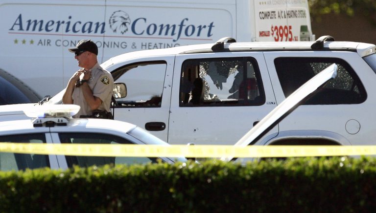 A vehicle is riddled with bullet holes at the scene of a fatal shooting at a gas station in Moreno Valley, Calif., Tuesday, July 22, 2014. Authorities in Riverside County are searching for a gunman who investigators say shot and killed two people and may be connected to the wounding of a deputy during a shootout. (AP Photo/The Press-Enterprise, Stan Lim) MAGS OUT