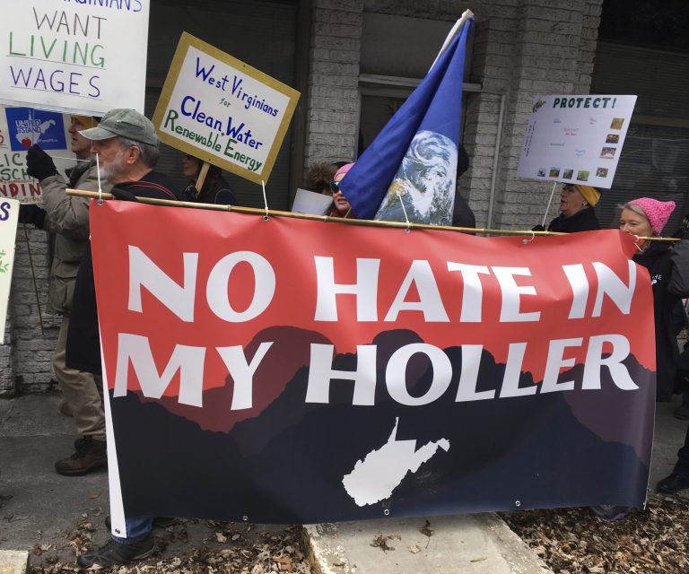 Demonstrators protest President Donald Trump's policies and threats to safety net programs, Thursday, Feb. 1, 2018, in White Sulphur Springs, W.Va. (AP Photo/Michael Virtanen)