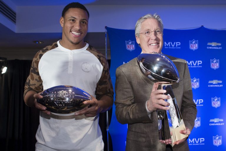 Seattle Seahawks head coach Pete Carroll, right, poses for a photograph with the Vince Lombardi trophy alongside Super Bowl XLVIII MVP Malcolm Smith, during a news conference at the Super Bowl Media Center at the Sheraton hotel, Monday, Feb. 3, 2014, in New York. The Seattle Seahawks defeated the Denver Broncos, 43-8. (AP Photo/John Minchillo)