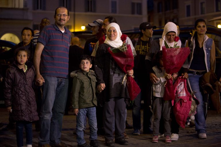Syrian refugees Wafa, no last name available, at center with white scarf, and her husband Osama, second from left, hold their children's hands as they arrive with another Syrian family at the St. Egidio Community in Rome, Saturday, April 16, 2016. (AP Photo/Alessandra Tarantino)