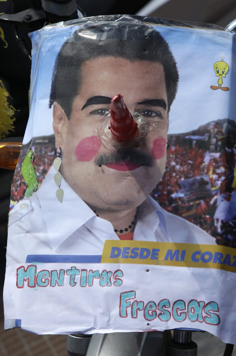 A sign poking fun of ruling party presidential candidate Nicolas Maduro is seen during an opposition campaign rally ahead of next week end's presidential election in Caracas, Venezuela, Sunday, April 7, 2013. Tens of thousands of opposition candidate Henrique Capriles backers converged on a main avenue in downtown Caracas for Sunday's rally. The writting reads in Spanish 