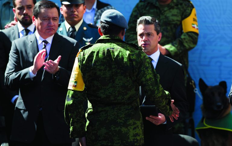 Mexico's President Enrique Pena Nieto awards a certificate of recognition to an emergency worker for his efforts in the aftermath of last week's explosion at the Mexico's state-owned oil company Petroleos Mexicanos or Pemex, that killed 37 people in Mexico City, Friday, Feb. 8, 2013. A gas buildup ignited by an electrical spark or other heat source caused the blast that killed the 37 people and wounded dozens said Mexico's attorney general. (AP Photo/Eduardo Verdugo)