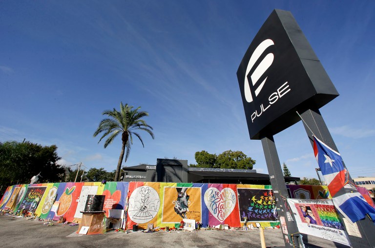 In this Wednesday, Nov. 30, 2016 photo, artwork and signatures cover a fence around the Pulse nightclub, scene of a mass shooting, in Orlando, Fla. The Department of Justice announced its Office for Victims of Crime would grant $8.5 million to the victims. (AP Photo/John Raoux)