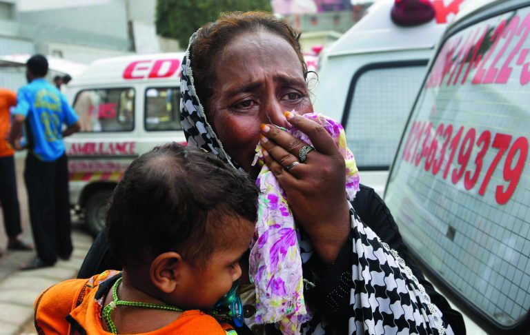 A Pakistani woman mourns the death of her family member outside a mortuary in Karachi, Pakistan, Wednesday, Sept. 12, 2012. Pakistani officials say the death toll from devastating factory fires that broke out in two major cities has killed dozens. (AP Photo/Fareed Khan)