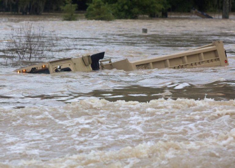 In this Aug. 14, 2016 file photo, a Louisiana Army National Guard dump truck that drove off the road is submerged in flood waters near Walker, La., after heavy rains inundated the region. This past summer's weather was relentless and hellish, crowded with the type of record-smashing extremes that scientists have long warned about. (AP Photo/Max Becherer)