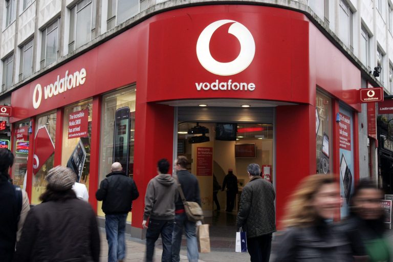 FILE - In this Tuesday, Feb. 24, 2009 file photo, people walk by a Vodafone branch in central London. Vodafone, one of the world's largest cellphone companies, on Friday, June 6, 2014 revealed the scope of government snooping into phone networks, saying authorities in some countries are able to directly access an operator's network without seeking permission. (AP Photo/Sang Tan, File)