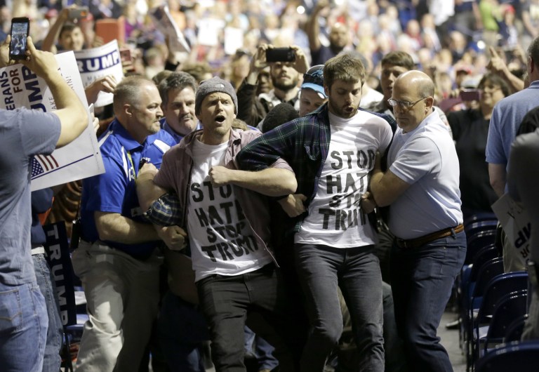 Protesters are removed as Republican presidential candidate Donald Trump speaks during a campaign rally. (AP Photo/Gerry Broome)