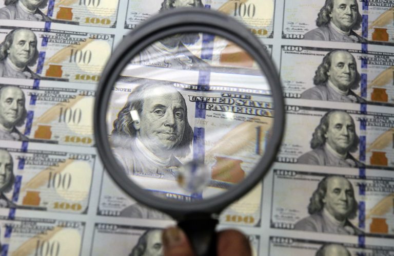 FILE - In this Sept. 24, 2014 file photo, a sheet of uncut $100 bills is inspected during the printing process at the Bureau of Engraving and Printing Western Currency Facility in Fort Worth, Texas. A strengthening U.S. economy, combined with a gloomy outlook for growth elsewhere in the world, is pushing the U.S. currency to its highest level in more than a year. (AP Photo/LM Otero, File)