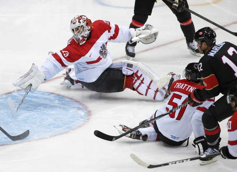 Austria goaltender Bernhard Starkbaum reaches back as the puck shot by Canada forward Jeff Carter, flies into the net for a goal in the second period of a men's ice hockey game at the 2014 Winter Olympics, Friday, Feb. 14, 2014, in Sochi, Russia. (AP Photo/Julio Cortez)