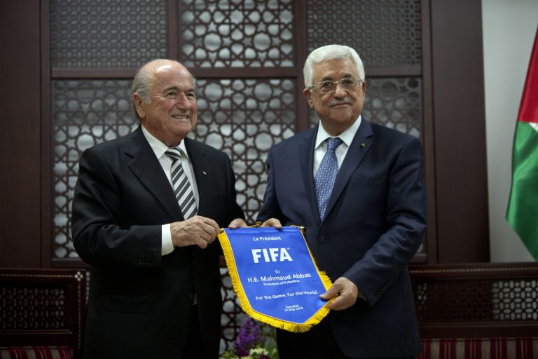 Sepp Blatter, President of FIFA, left, gives a gift with the FIFA logo to Palestinian President Mahmoud Abbas during a meeting at the presidential headquarters on the first day of his regional tour to Jordan, Palestine and Israel in the West Bank city of Ramallah, Monday, May 26, 2014. During an earlier press conference in Jordan Blatter said that his visit to Ramallah and Israel was to defend football in Palestine and also to defend football in Israel. (AP Photo/Majdi Mohammed)