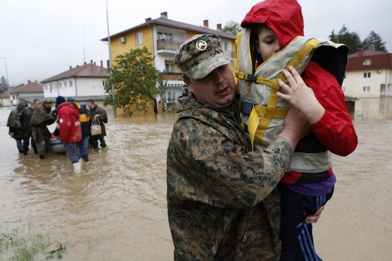 A member of the Bosnian army carries a boy rescued from his home, during floods,   in the Bosnian town of Maglaj, 150 kms north of Sarajevo, Friday May 16, 2014. Two people drowned in Serbia and the country declared a national emergency Thursday as rain-swollen rivers across the Balkans flooded roads and bridges, shut down schools and cut off power. Hundreds of people had to be evacuated. In Serbia and neighboring Bosnia, meteorologists said the rainfall was the most since measuring started 120 years ago. Belgrade authorities say the average rainfall of a two-month period hit the city in just 40 hours. (AP Photo/Amel Emric)